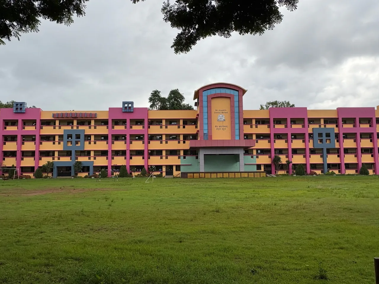 Front of the school building with the green field